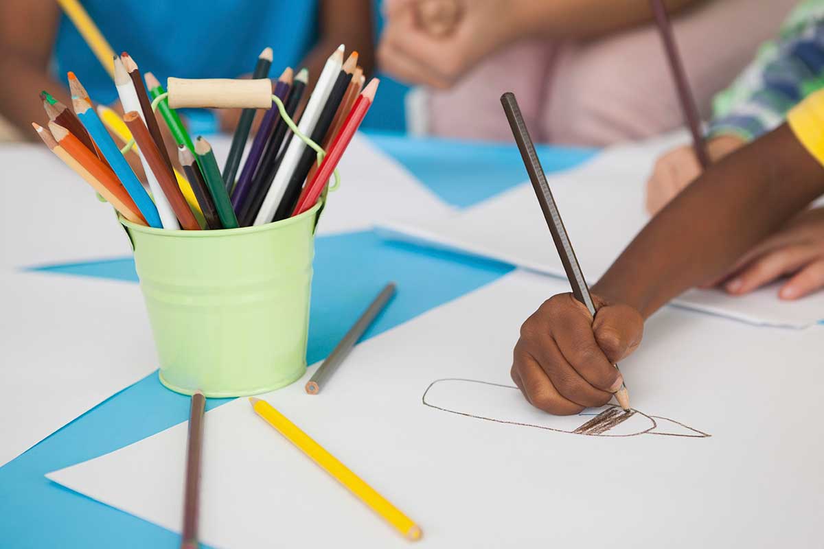 child drawing with colored pencils