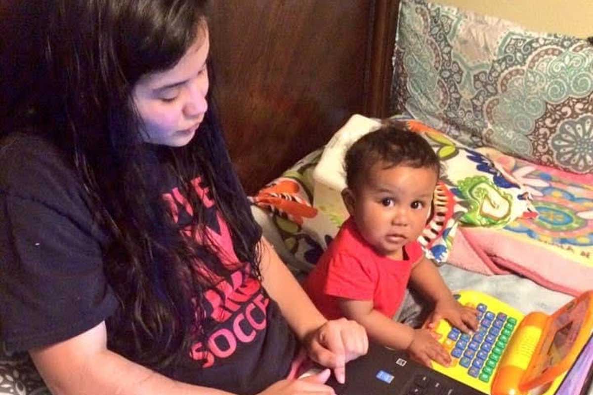 Western Oregon University student Denise Sanchez studying with her child.