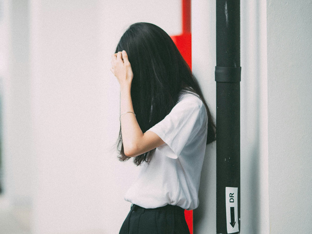 person leaning against wall