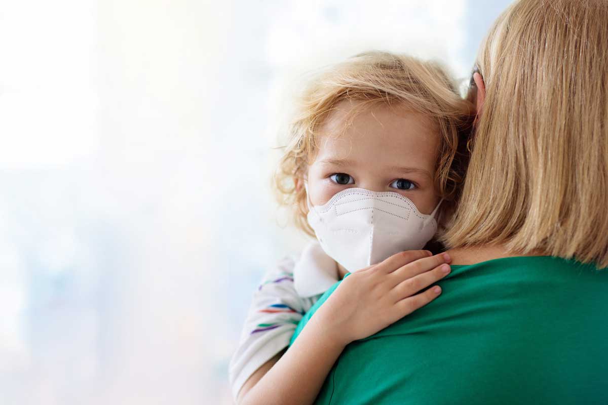 Mom holds child wearing mask